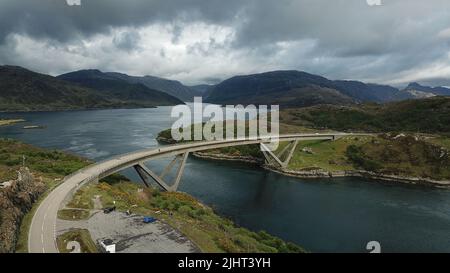 Un'immagine ad alto angolo del ponte Kylesku con montagne scozzesi scenografiche sullo sfondo Foto Stock