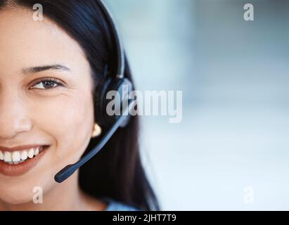 Rimanere cordiali, calmi e attenti alle esigenze dei clienti. Ritratto di un giovane agente del call center in ufficio. Foto Stock