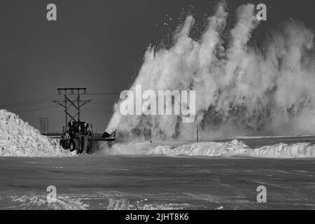 Una scala di grigi di un trattore che sgombrano la neve Foto Stock