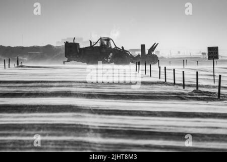 Una scala di grigi di un trattore che sgombrano la neve Foto Stock