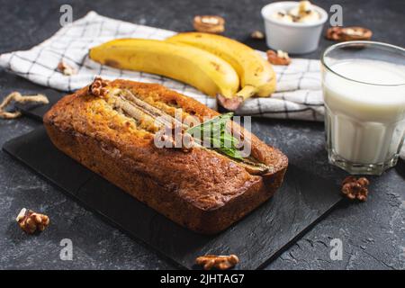 Pane alla banana o torta su tavola di pietra nera. Delizioso dessert fatto in casa, gustoso snack o colazione al mattino. Foto Stock