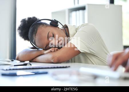 Un sonnellino di cinque minuti è una meraviglia: Un giovane agente di call center che dorme sulla scrivania in ufficio. Foto Stock