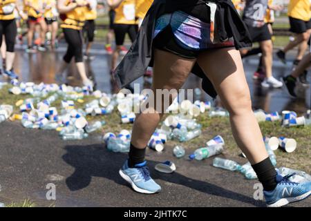 Le bottiglie di plastica e le tazze di carta gettate a terra durante Wings for Life World Run Foto Stock