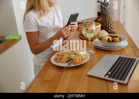 Primo piano di blogger femmina caucasico scattare foto con smartphone di pesce. Blogging. Foto Stock