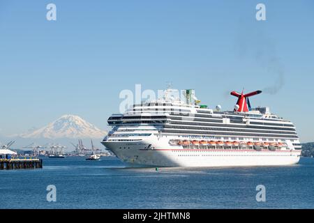 Seattle - 19 luglio 2022; Carnival Splendor con partenza da Seattle per l'Alaska con la vetta vulcanica innevata del Monte Rainier all'orizzonte Foto Stock