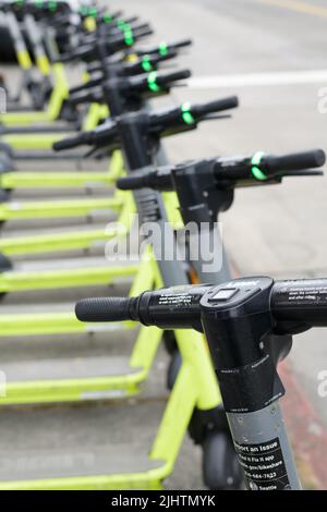 Seattle - 18 luglio 2022; una fila di SCOOTERS elettrici DI COLLEGAMENTO si levano in piedi lungo una strada a Seattle Foto Stock