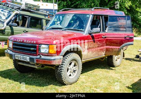 Vista frontale di un veicolo fuoristrada Land Rover Discovery 2001 in rosso con sporcizia e fango sul lato visto qui al Berkshire Motor Show di Reading, Foto Stock