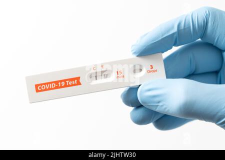 Hand mostra risultati positivi sul kit per test antigenici rapidi per il covid-19. Foto Stock