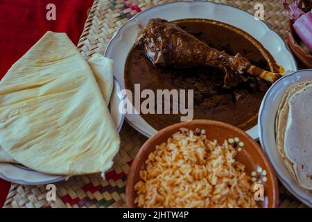 Avvolto con mole di San Lucas Atzala, Puebla con tortilla di mais rosso Foto Stock