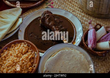 Avvolto con mole di San Lucas Atzala, Puebla con tortilla di mais rosso Foto Stock