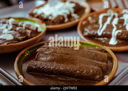 Avvolto con mole di San Lucas Atzala, Puebla con tortilla di mais rosso Foto Stock