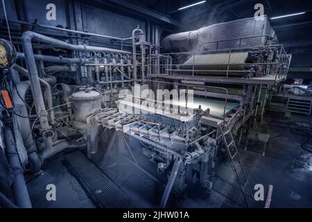 Macchina di produzione con rotoli di carta nuova in fabbrica di riciclaggio della carta di scarto. Foto Stock