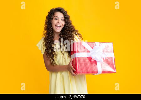 Regalo emotivo del bambino adolescente in attesa per il compleanno. Divertente ragazza di capretto che tiene le scatole del regalo che celebra l'anno nuovo felice o il Natale. Adolescente eccitato, contento Foto Stock