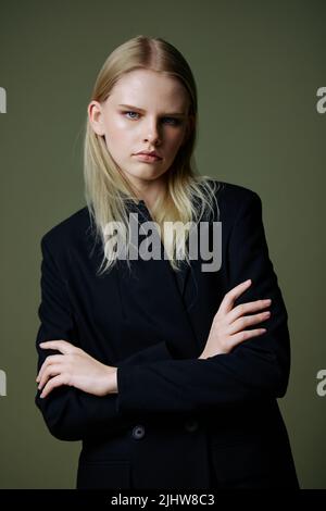 Il concetto del movimento delle donne. Una ragazza forte di successo sicuro di sé seria attraversa le braccia sul petto e guarda nella fotocamera in posa su Foto Stock