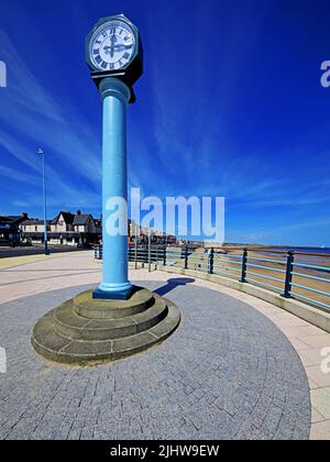 Whitley Bay Promenade in una giornata di sole e il grande orologio blu con il Mare del Nord e un cielo blu profondo con diagonale nuvola di cirro Foto Stock