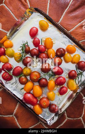 pomodori rossi, gialli, a ciliegia d'arancia per tostatura al rosmarino Foto Stock