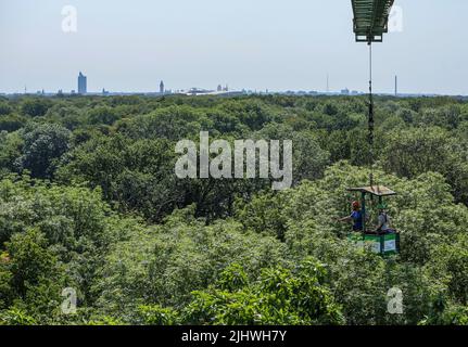 20 luglio 2022, Sassonia, Lipsia: Julia van Braak e Tom Künne, dipendenti dell'Università di Lipsia, utilizzano una gondola per raccogliere campioni da una gru nella foresta della pianura come parte del Centro tedesco di ricerca integrativa sulla biodiversità (iDiv) Halle-Jena-Leipzig. La gru forestale della pianura alluvionale consente agli scienziati di penetrare nelle cime degli alberi. La mancanza di precipitazioni mette in pericolo anche la popolazione di alberi nella foresta della pianura di Lipsia. Sycamore, quercia e soprattutto cenere sono particolarmente colpiti. I botanisti presumono che circa la metà dell'intera popolazione di alberi di cenere nella foresta della pianura alluvionale wi Foto Stock