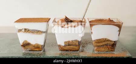 Ciotole con dolce e gustoso tiramisù sul tavolo Foto Stock