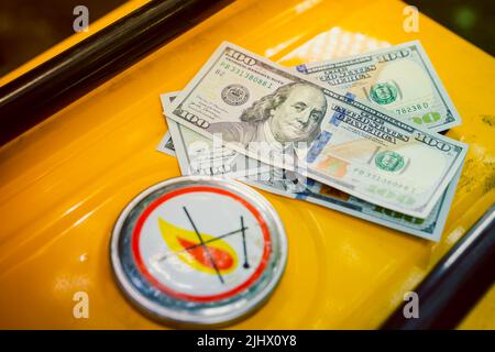 Cartello infiammabile sul tappo del serbatoio del gas del generatore di gas e closeup bollette da cento dollari Foto Stock