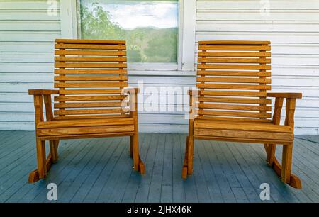 Due sedie a dondolo in legno su un portico in legno bianco Foto Stock