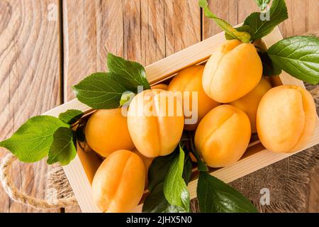 vista dall'alto di grandi albicocche succose in una scatola di legno. raccolto di agricoltura. presentazione del prodotto. pubblicità della frutta Foto Stock