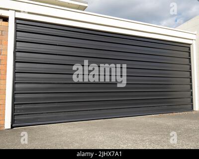 Garage con sportello in metallo ribaltabile e retrattile verniciato nero. Copia foto scorta spazio. Foto Stock