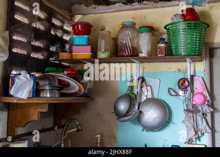 Attrezzatura da cucina sulle mensole e sulle pareti di una casa di campagna Foto Stock