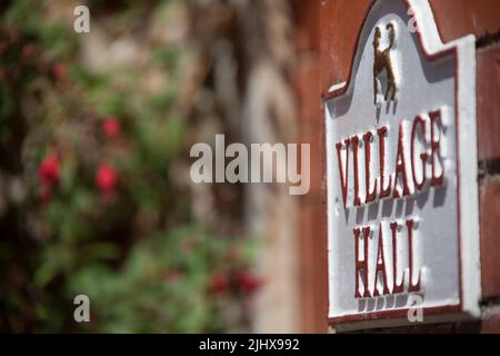 Villaggio di Eccleston, Inghilterra. Vista ravvicinata pittoresca del cartello Village Hall Eaton Estate. Foto Stock