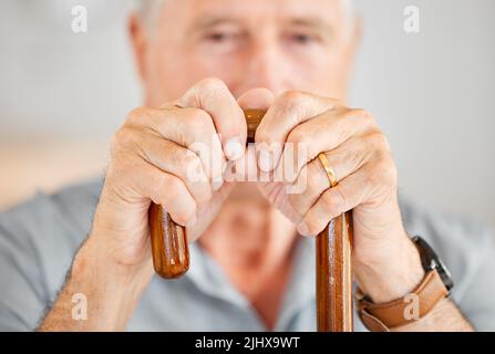 Questo mi aiuta davvero a muoversi. Primo piano di un uomo anziano che tiene un bastone da passeggio. Foto Stock