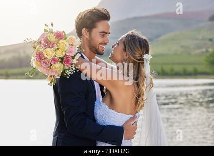 Celebrare l'amore e la felicità. Una sposa affettuosa e sposare fuori il loro giorno di nozze. Foto Stock