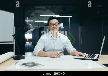 Ritratto di successo asiatico maschio architetto sorridente e guardando la macchina fotografica, lavorando al progetto di disegno in studio di design ufficio Foto Stock