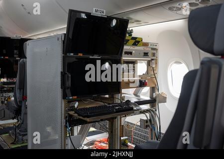 Attrezzatura di prova di volo nella cabina di un Boeing 737 Max 10 Airliner, la variante sperimentale del 737 che sostituisce il 737 Max, il modello che ha subito incidenti fatali in Indonesia e Kenya, al Farnborough Airshow, il 20th luglio 2022, a Farnborough, Inghilterra. A causa degli incidenti, le 737 flotte Max in tutto il mondo sono state fondate con il produttore di aviazione statunitense che ora si è recuperato da una crisi finanziaria. La cabina di prova di volo è configurata per stazioni di lavoro e cavi di computer che trasmettono i dati mentre la zavorra d'acqua trasferisce le informazioni di peso e centro di gravità ai sensori durin Foto Stock