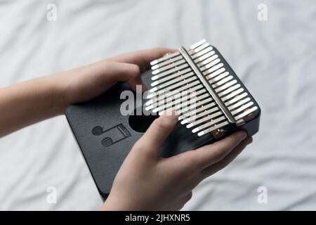 primo piano dello strumento musicale africano in mano o in persona che suona su kalimba Foto Stock