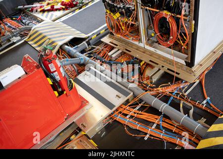 Attrezzatura di prova di volo nella cabina di un aereo di linea Boeing 777X, durante il salone aereo di Farnborough, il 20th luglio 2022, a Farnborough, Inghilterra. A causa degli incidenti mortali del 737 Max, la flotta del 737 è stata fondata in tutto il mondo e Boeing si sta ora riprendendo da una conseguente crisi finanziaria. La cabina di prova di volo è configurata per stazioni di lavoro e cavi di computer che trasmettono i dati mentre la zavorra d'acqua trasferisce le informazioni sul peso e sul centro di gravità ai sensori durante il volo, raccogliendo le informazioni sulle prestazioni calibrate prima dell'eventuale certificazione ufficiale dell'aeromobile. Foto Stock