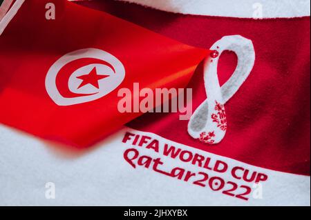 QATAR, DOHA, 18 LUGLIO 2022: Tunisia bandiera nazionale e logo della Coppa del mondo FIFA Qatar 2022 su tappeto rosso. Sfondo dello sport di calcio, spazio di modifica. Qatar 2 Foto Stock