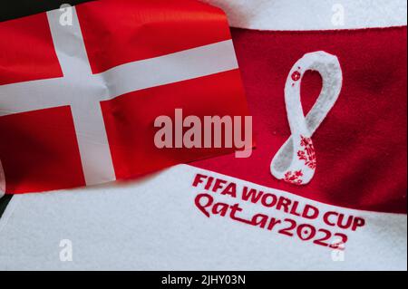 QATAR, DOHA, 18 LUGLIO 2022: Danimarca bandiera nazionale e logo della Coppa del mondo FIFA in Qatar 2022 su tappeto rosso. Sfondo dello sport di calcio, spazio di modifica. Qatar 2 Foto Stock