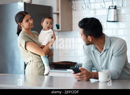Potete prestare attenzione a noi, un giovane che ignora sua moglie e suo figlio mentre usa il telefono a casa. Foto Stock