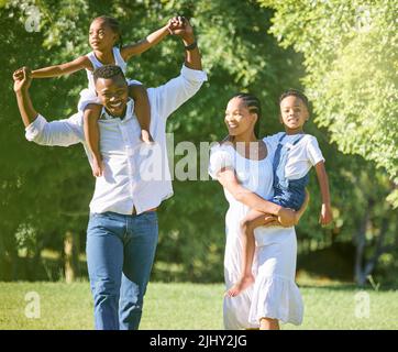 La famiglia rende la vita ancora più bella: Una coppia che passa il tempo all'aria aperta con i suoi due figli. Foto Stock