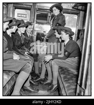 WW2 Ragazze da terra delle donne in una carrozza ferroviaria, indossando i loro braccioli WLA durante il tragitto verso le rispettive fattorie terrestri. Battaglia della Terra - il lavoro agricolo dell'Esercito della Terra delle Donne sul fronte domestico britannico che fornisce verdure alimentari fresche essenziali al Regno Unito, 1942 seconda guerra mondiale seconda guerra mondiale WW2 Foto Stock