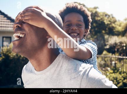 Ritratto di un felice afroamericano che si lega con il suo giovane ragazzino fuori. Due maschi neri padre e figlio che sono felici e positivi mentre Foto Stock