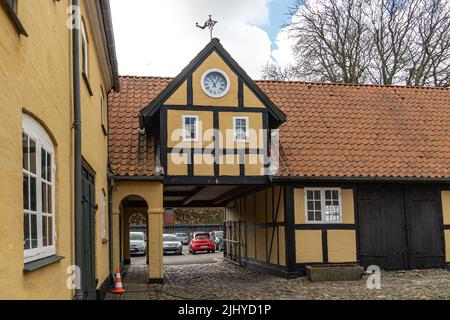 Dettagli architettonici di un tradizionale edificio danese con l'orologio e la paletta del vento. Assens, Danimarca, Europa Foto Stock