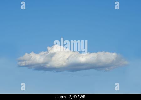 Copia lo spazio con una nuvola isolata contro un cielo blu chiaro in una giornata di sole fuori. Una nuvola bianca e soffice galleggiante in un paesaggio tranquillo Foto Stock