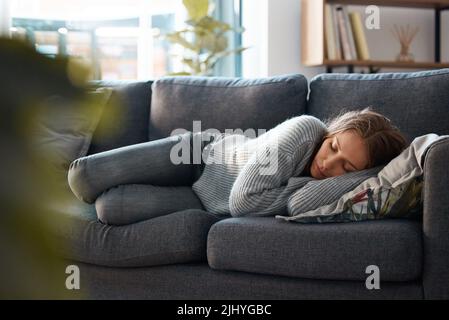 Perché mi sento così: Una giovane donna sdraiata sul divano si sente depressa. Foto Stock