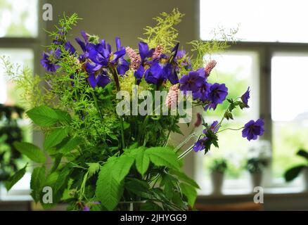 Mazzo di gru prato-fattura in un vaso come decorazione per una celebrazione o una cerimonia nuziale. Un bel bouquet di fiori viola come decor ad un evento Foto Stock