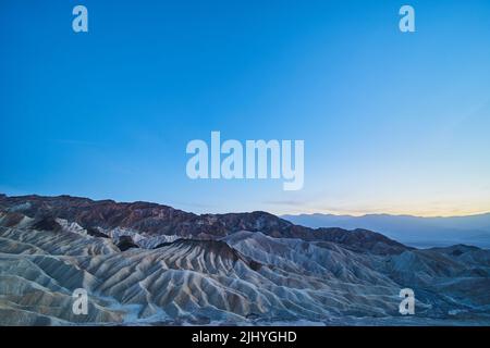 Zabriskie Point nella Valle della morte al crepuscolo con luce soffusa Foto Stock