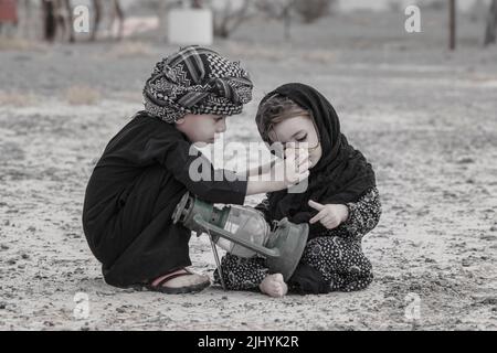 Un'immagine spontanea di due fratelli in cui il fratello cerca di modificare il burqa di sua sorella per apparire bello nella foto. Foto Stock