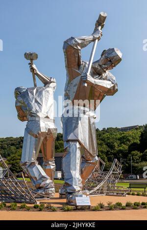 Sculture d'arte in acciaio inossidabile chiamate 'costruttori di Port Glasgow' da John McKenna nel Parco di Coronation, Port Glasgow raffiguranti operai Foto Stock