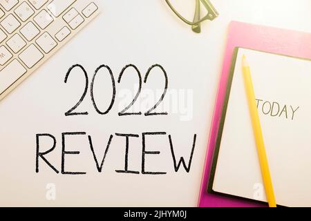 Un vettore di scrittura '2022 Review' segno vicino notebook con 'oggi' segno in bianco sfondo Foto Stock