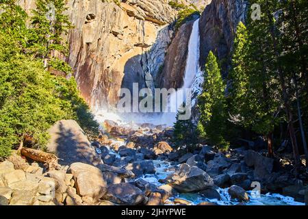 Cascate di Yosemite all'inizio di aprile con rocce ghiacciate e arcobaleno piccolo Foto Stock