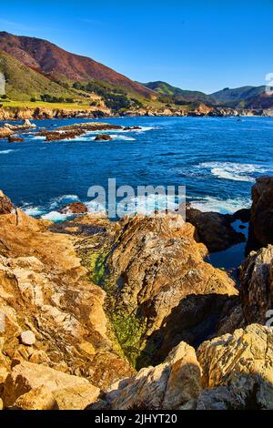 Vista sulla costa rocciosa con l'oceano Foto Stock